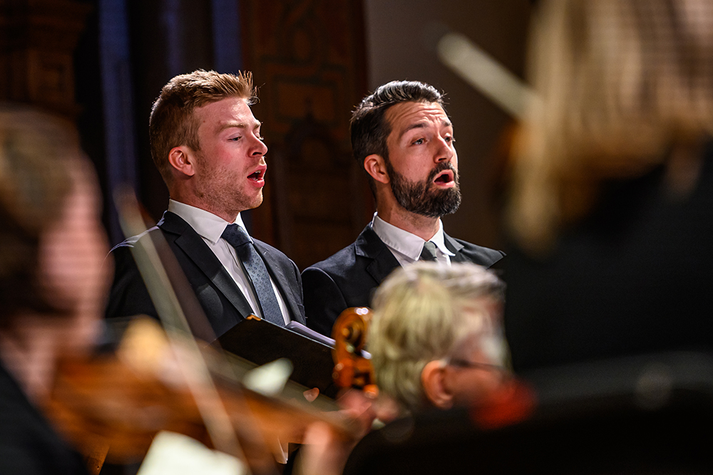 A close-up of Cory Knight, tenor, singing amongst the Tafelmusik Chamber Choir in Jeanne Lamon Hall