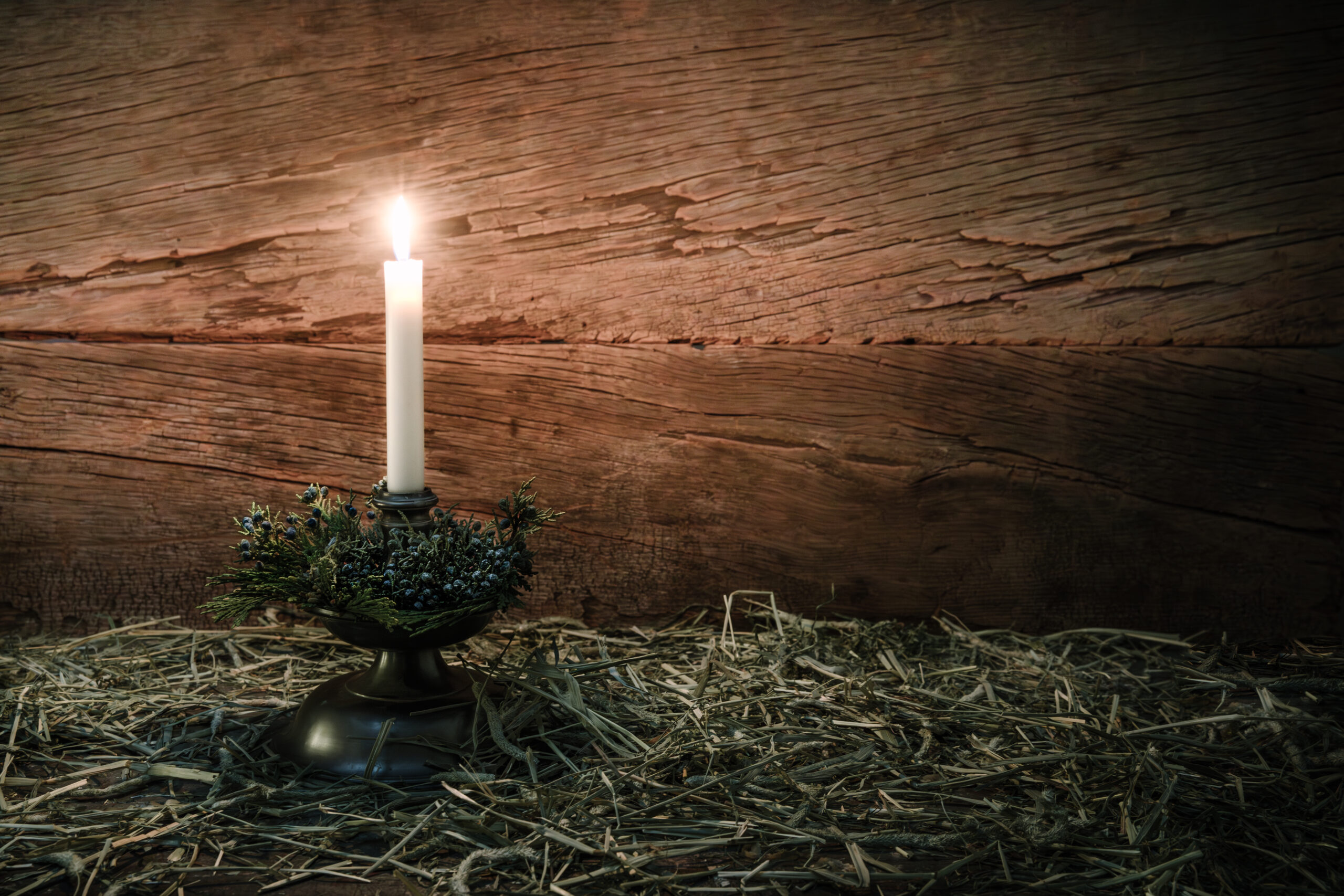 A candle burning on a pile of hay