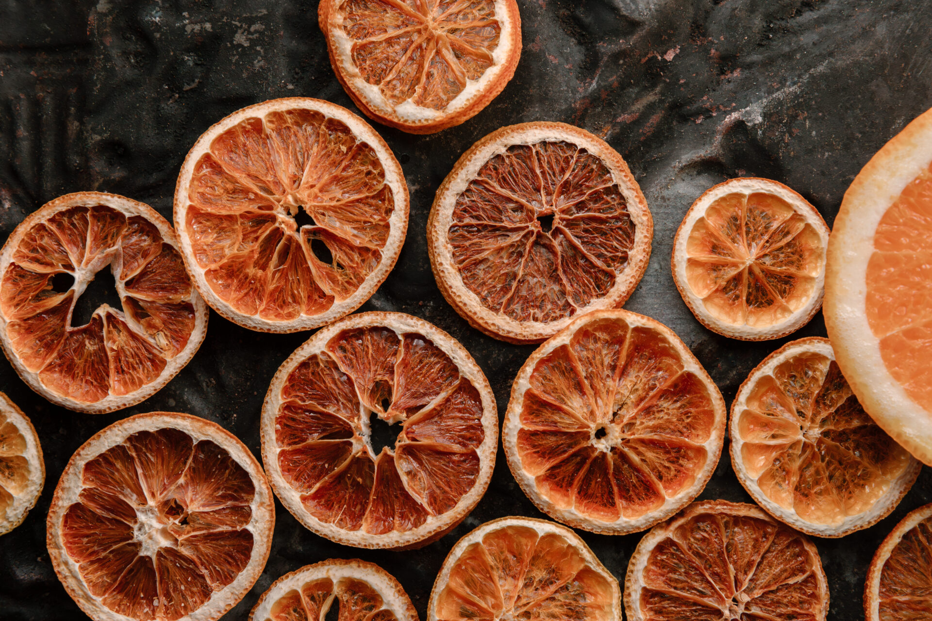 Sliced dried oranges on a black background.